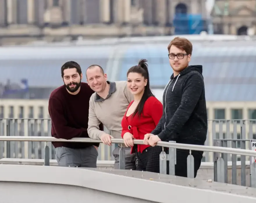 Four members of the 24metrics team on a rooftop in Berlin, including CEO Sven, a sales representative, and two engineers.